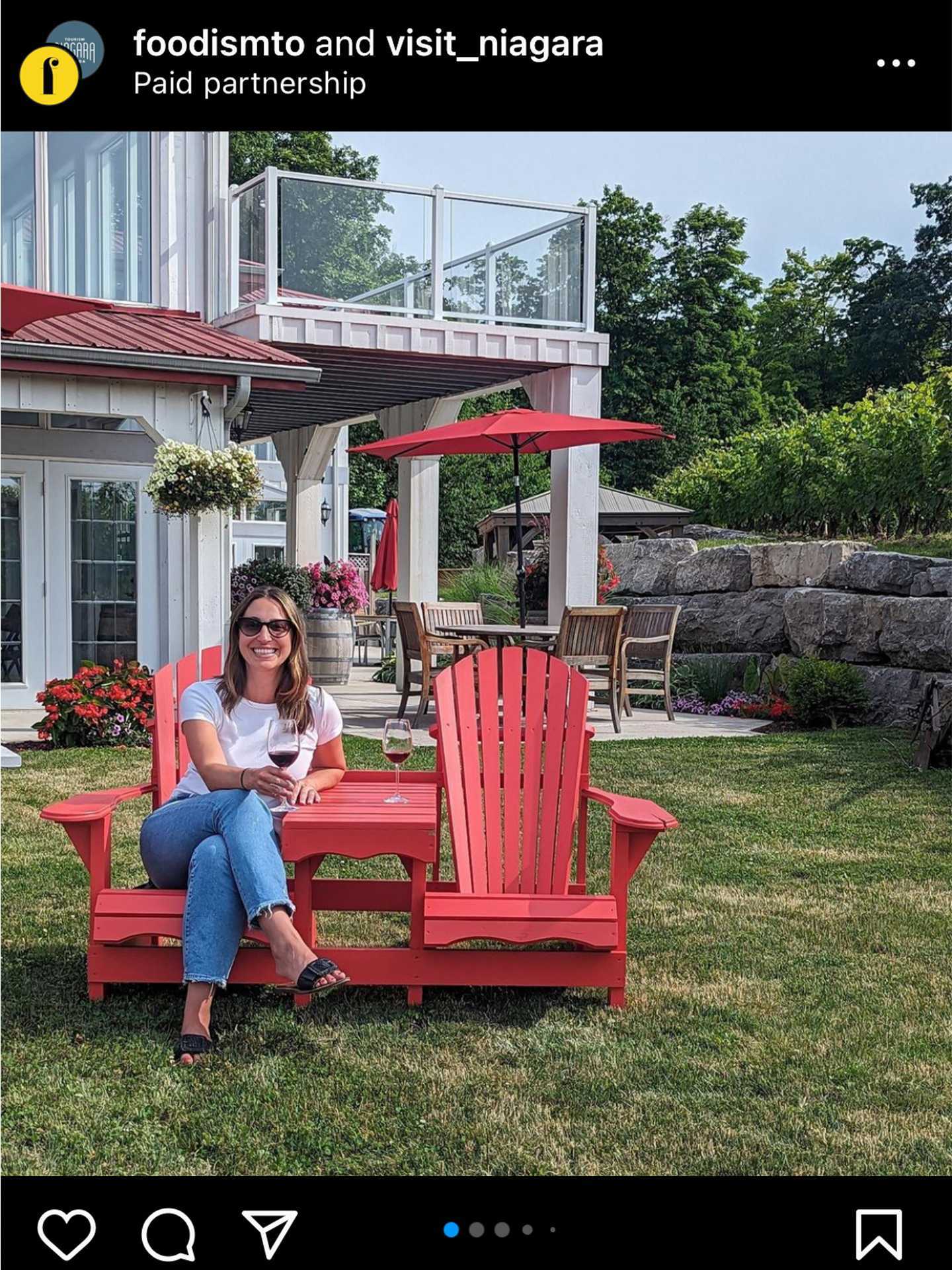 A woman sitting on a Muskoka chair at Kacaba Vineyards and Winery